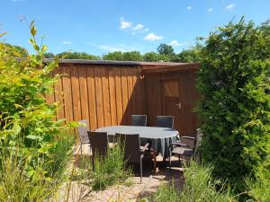 un patio con mesa, sillas y una valla en Ferienwohnung Rügen in Samtens, en Samtens