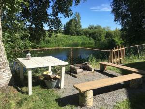 una mesa de picnic y un banco frente a un estanque en Tomujoen Kylätalo, en Himanka