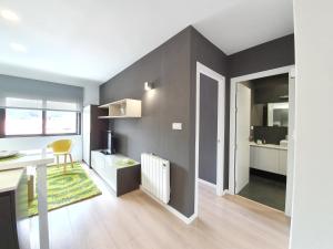 ein Wohnzimmer mit grauen Wänden und einem Schreibtisch in der Unterkunft Bruma Marina in A Guarda