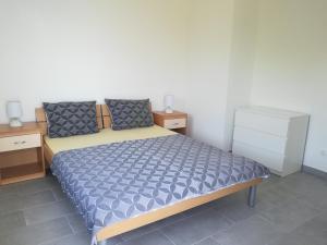 a bedroom with a bed with a blue comforter at Villa Adagio Apartments in Sumartin