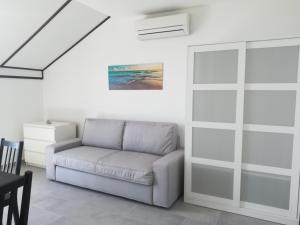 a living room with a couch and a sliding glass door at Villa Adagio Apartments in Sumartin