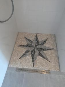 a star decoration on a tile floor in a bathroom at Villa Adagio Apartments in Sumartin