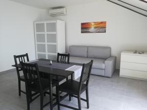 a dining room with a table and chairs and a couch at Villa Adagio Apartments in Sumartin