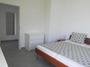 a white bedroom with a bed and a dresser at Villa Adagio Apartments in Sumartin