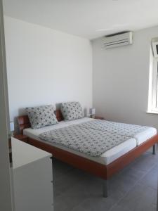 a bed in a room with a white wall at Villa Adagio Apartments in Sumartin