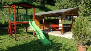 einen Spielplatz mit Rutsche und Pavillon in der Unterkunft Apartma Bača in Most na Soči
