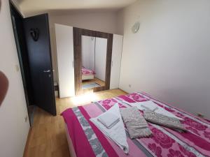 a bedroom with a bed with pink sheets and a mirror at Apartment Old Town in Pula