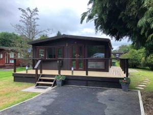 a tiny house with a deck in a yard at 49 Irfon Lodge no commerical vehicles or tradesmen allowed in Builth Wells