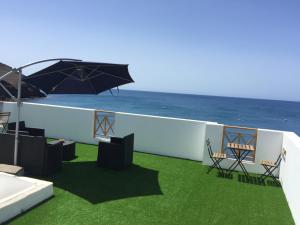 - un balcon avec des chaises et un parasol donnant sur l'océan dans l'établissement La Lajita Ocean View, à Lajita