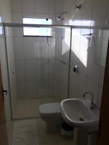 ein Bad mit einer Dusche, einem WC und einem Waschbecken in der Unterkunft BRAVO CITY HOTEL CAMPO VERDE in Campo Verde