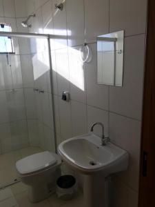 ein weißes Bad mit einem Waschbecken und einem WC in der Unterkunft BRAVO CITY HOTEL CAMPO VERDE in Campo Verde
