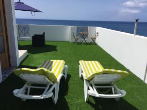 2 sillas amarillas y blancas en un balcón con vistas al océano en La Lajita Ocean View 2, en Lajita