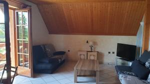 a living room with a couch and a table at location à la campagne aux portes de Mulhouse in Sausheim