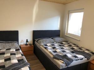 1 dormitorio con 2 camas y ventana en Penzion Zaječský šenk, en Zaječí