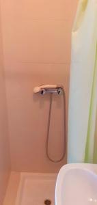 y baño con cortina de ducha y lavamanos. en Hostal El Cairo en Ferrol