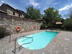 a swimming pool in a yard with a stone wall at Los Tres Albares in Lardiés