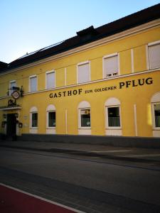 ein gelbes Gebäude mit dem Namen des gegossenen Randalls-Pubs in der Unterkunft Gasthof zum Goldenen Pflug in Amstetten