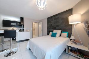 a bedroom with a bed and a desk and a kitchen at :) Grand studio lumineux à Toulouse et parking in Toulouse