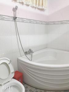 y baño con bañera blanca y aseo. en Khách Sạn Ngọc Cường en Bạc Liêu