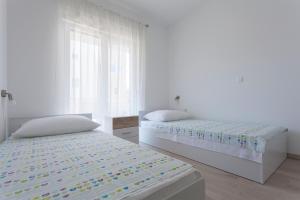 a white bedroom with two beds and a window at Atena Zaton 2 in Nin +87 photos