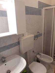 a bathroom with a white toilet and a sink at Cortile Maggiore Home in Cefalù