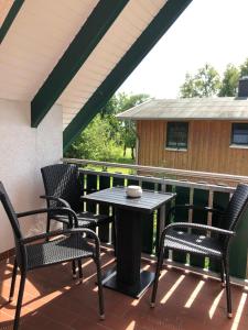 un patio con mesa y sillas en la azotea en Zingst Haus Hugo, en Zingst