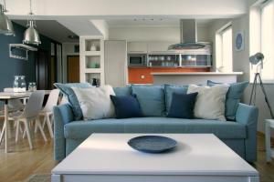 a living room with a blue couch and a table at Siesta Apartments in Sopot