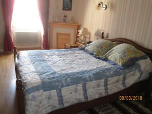 a bedroom with a bed with a blue and white quilt at GITE A SAINT-REMY (21500) in Saint-Rémy