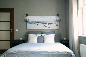 a bedroom with a bed with a picture on the wall at Siesta Apartments in Sopot