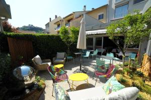 a patio with chairs and a table and an umbrella at Urban Style L'Etape in Saint-Flour