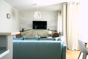 a living room with a blue couch and a flat screen tv at Siesta Apartments in Sopot