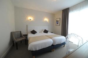 Un pat sau paturi într-o cameră la Cit'Hotel Grand Hotel L'Etape