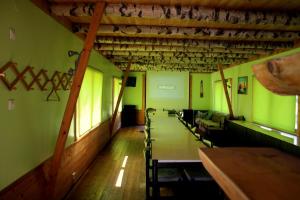 a row of tables and chairs in a room with green walls at Pedaja Puhketalu in Nulga