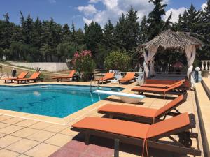 a pool with a bunch of chairs and a bunch ofitures at Villa Askamnia and Suites in Nikiti