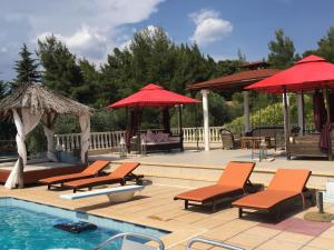 a swimming pool with chairs and umbrellas and a pool at Villa Askamnia and Suites in Nikiti
