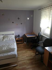 1 dormitorio con cama, escritorio y escritorio en Gästehaus Querenhorst, en Querenhorst