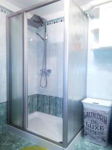 La salle de bains est pourvue d'une douche avec une porte en verre. dans l'établissement La Suite, à Candide
