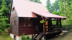 Cabaña pequeña con techo rojo en Chatka Nad Strumieniem en Glinka