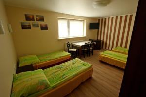 a room with three beds and a table and a dining room at U ELŻBIETY in Łeba