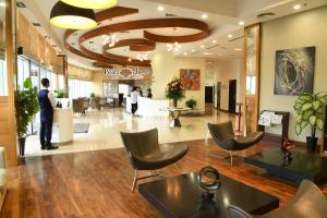 a lobby of a hair salon with chairs and people at Gulf Suites Hotel Amwaj in Manama