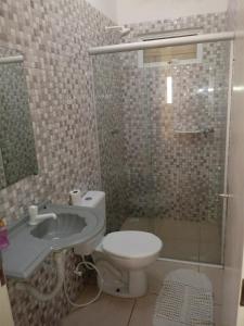 a bathroom with a toilet and a shower and a sink at Casa Larithur in Beberibe