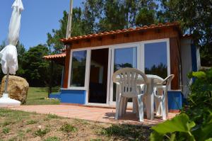a small cabin with a table and chairs in front of it at Quinta dos Mangues in São Martinho do Porto