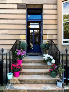 uma porta da frente de um edifício com vasos de plantas em New Town Guest House (Adults Only) em Edimburgo