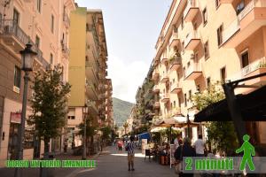 una strada cittadina con edifici e persone che camminano per strada di B&B Portafortuna Lucky charm a Salerno
