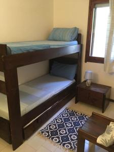 1 dormitorio con 2 literas y mesa en Splendida villetta Kal'e Moru en Marongiu