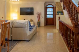 a living room with a couch and a tv on the wall at Cactus Ville Playa in Arinaga