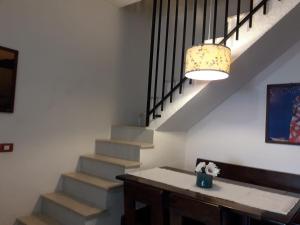 Zimmer mit einer Treppe, einem Tisch und einer Lampe in der Unterkunft Splendida villetta Kal'e Moru in Marongiu