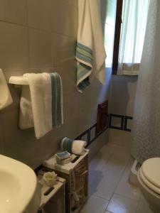 a bathroom with a sink and a toilet and towels at Splendida villetta Kal'e Moru in Marongiu +21 photos