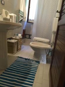 Splendida villetta Kal'e Moru في Marongiu: حمام مع مرحاض ومغسلة وسجادة