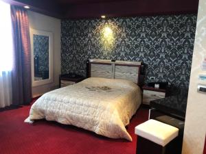 una camera con letto e tappeto rosso di Grand Hotel Petrol a Fier